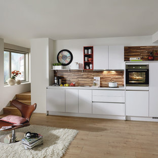 Inspiration pour une cuisine ouverte linéaire nordique de taille moyenne avec des portes de placard blanches, aucun îlot et une crédence marron.