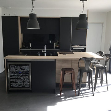 cuisine contemporaine en laque mate noire bois mur d'armoires et îlot dinatoire