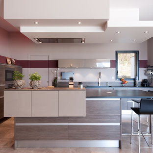 Cette photo montre une cuisine ouverte tendance en L de taille moyenne avec un îlot central, des portes de placard marrons, un plan de travail en granite, une crédence marron, un électroménager en acier inoxydable et un placard à porte plane.