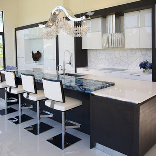 Exemple d'une très grand cuisine ouverte parallèle tendance avec un évier encastré, un placard sans porte, des portes de placard blanches, un plan de travail en quartz, une crédence blanche, une crédence en carreau de verre, un électroménager blanc et un îlot central.