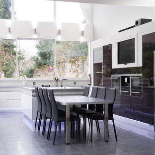 Aménagement d'une grand cuisine ouverte contemporaine en U avec une crédence blanche, un électroménager en acier inoxydable, un îlot central et des portes de placard noires.
