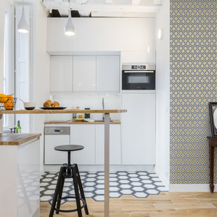 Idée de décoration pour une cuisine ouverte linéaire nordique avec un placard à porte plane, des portes de placard blanches, un plan de travail en bois, un électroménager en acier inoxydable, un sol multicolore, un plan de travail marron, un évier encastré, une crédence blanche, une crédence en carreau de verre, un sol en carreaux de ciment et aucun îlot.