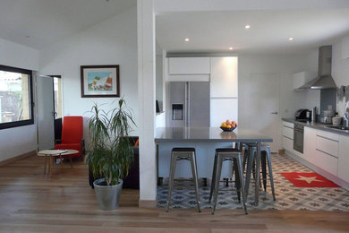 Modern inredning av ett mellanstort kök, med vita skåp, grått stänkskydd, cementgolv, en köksö, grått golv, en integrerad diskho, bänkskiva i koppar och rostfria vitvaror