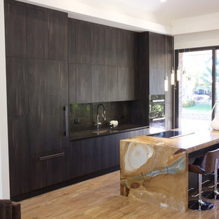 Idées déco pour une cuisine ouverte parallèle contemporaine de taille moyenne avec un évier encastré, un placard à porte affleurante, des portes de placard marrons, un plan de travail en quartz, une crédence marron, un électroménager encastrable, un sol en bois clair et un îlot central.