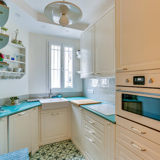 Inspiration for a transitional u-shaped kitchen in Paris with a farmhouse sink, raised-panel cabinets, white cabinets, grey splashback, subway tile splashback, white appliances, no island, multi-coloured floor and turquoise benchtop.