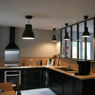 Inspiration for a large industrial open plan kitchen in Bordeaux with an integrated sink, black cabinets, wood benchtops, black splashback, timber splashback, stainless steel appliances, cement tiles, multiple islands and white floor.