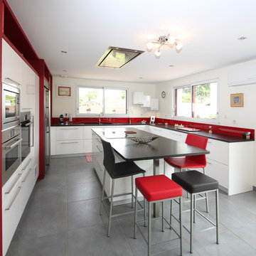 Cuisine moderne laquée blanche avec îlot central et plan de travail en granit.