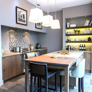 Cette image montre une cuisine parallèle design de taille moyenne avec un plan de travail en granite, une crédence en pierre calcaire, un sol en carrelage de céramique, une péninsule, un sol gris, un plan de travail beige, un évier encastré et une crédence grise.