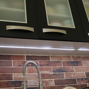 Small industrial enclosed kitchen designs - Inspiration for a small industrial l-shaped linoleum floor and black floor enclosed kitchen remodel in Paris with a single-bowl sink, beaded inset cabinets, black cabinets, laminate countertops, red backsplash, brick backsplash, black appliances and no island