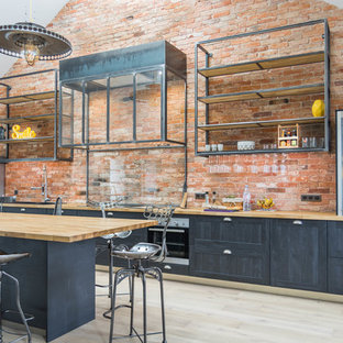 Cette image montre une cuisine linéaire urbaine avec un placard à porte shaker, des portes de placard grises, un plan de travail en bois, un îlot central, un sol beige et un plan de travail beige.