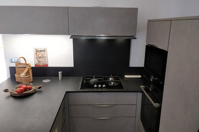 Inspiration pour une cuisine américaine design en U de taille moyenne avec un plan de travail en granite et plan de travail noir.