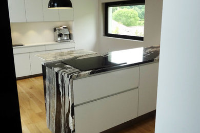 Imagen de cocina contemporánea de tamaño medio abierta con fregadero de un seno, encimera de granito, electrodomésticos de acero inoxidable y suelo de madera clara