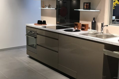 Medium sized contemporary galley open plan kitchen in Grenoble with a single-bowl sink, beaded cabinets, beige cabinets, quartz worktops, grey splashback, metro tiled splashback, stainless steel appliances, cement flooring, an island and grey floors.