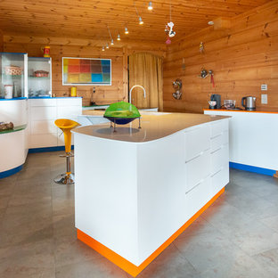 Idées déco pour une cuisine éclectique avec un placard à porte plane, des portes de placard blanches, un îlot central et un sol gris.