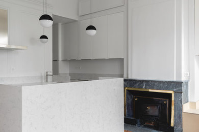 Foto de cocina contemporánea de tamaño medio abierta con fregadero bajoencimera, encimera de cuarcita, salpicadero blanco, suelo de madera clara y una isla