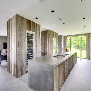 Réalisation d'une grand cuisine ouverte linéaire design avec un évier encastré, un placard à porte plane, des portes de placard en bois vieilli, un électroménager en acier inoxydable, un îlot central et un sol en carrelage de céramique.
