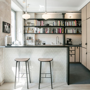 Inspiration pour une cuisine américaine nordique en L avec un évier encastré, un placard à porte affleurante, des portes de placard en bois clair, un plan de travail en béton, une crédence verte, une crédence en carreau de céramique, un électroménager encastrable, béton au sol, une péninsule, un sol bleu et un plan de travail bleu.
