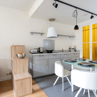 Exemple d'une petit cuisine ouverte linéaire tendance avec des portes de placard grises, un plan de travail en quartz, une crédence grise, un sol en linoléum, un sol gris, un plan de travail blanc, un placard à porte plane et une crédence en feuille de verre.