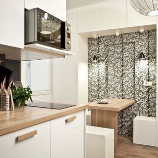 Esempio di una cucina minimal di medie dimensioni con ante bianche, paraspruzzi nero, pavimento in legno massello medio e nessuna isola