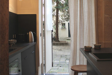 Ejemplo de cocina de estilo de casa de campo con salpicadero negro y electrodomésticos negros