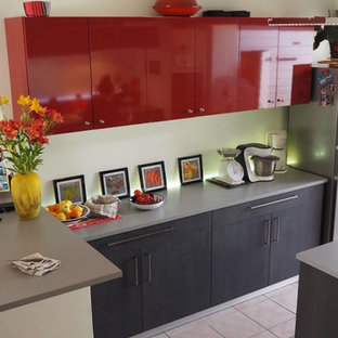 Design ideas for a large modern galley open plan kitchen in Nantes with a single-bowl sink, flat-panel cabinets, dark wood cabinets, laminate benchtops, red splashback, glass sheet splashback, stainless steel appliances, ceramic floors, with island and pink floor.