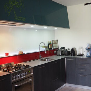 Design ideas for a large modern galley open plan kitchen in Nantes with a single-bowl sink, flat-panel cabinets, dark wood cabinets, laminate benchtops, red splashback, glass sheet splashback, stainless steel appliances, ceramic floors, with island and pink floor.