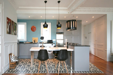 Exemple d'une cuisine ouverte éclectique en L de taille moyenne avec des portes de placard grises et îlot.