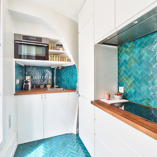 Idées déco pour une cuisine ouverte contemporaine en L de taille moyenne avec des portes de placard blanches, un plan de travail en bois, une crédence bleue, une crédence en carreau de terre cuite, un sol en carrelage de céramique, aucun îlot, un sol bleu, un évier encastré, un placard à porte affleurante, un électroménager en acier inoxydable et un plan de travail marron.