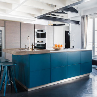 Exemple d'une cuisine américaine tendance avec un évier encastré, un placard à porte plane, des portes de placard marrons, un électroménager en acier inoxydable, un îlot central, un sol noir, un plan de travail marron et un plafond en poutres apparentes.