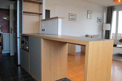 Cette photo montre une petite cuisine ouverte linéaire tendance en bois clair avec un placard avec porte à panneau encastré, un plan de travail en stratifié, un électroménager en acier inoxydable, îlot et un plan de travail gris.