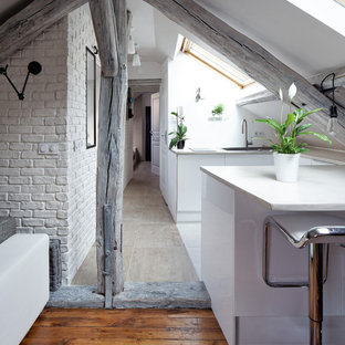 Idée de décoration pour une petit cuisine ouverte design en U avec un placard à porte plane, des portes de placard blanches et une péninsule.