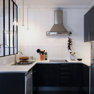 Cette photo montre une cuisine scandinave en U de taille moyenne et fermée avec un placard à porte plane, une crédence blanche, aucun îlot, un évier posé et un électroménager encastrable.