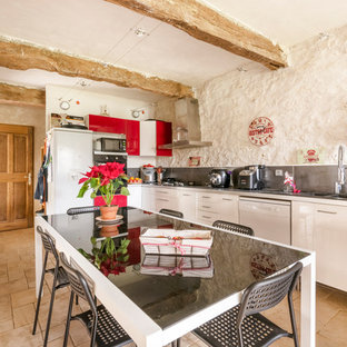 Cette image montre une cuisine américaine méditerranéenne en L avec un évier 2 bacs, un placard à porte plane, des portes de placard blanches, une crédence grise, un électroménager blanc, un sol beige et un plan de travail gris.
