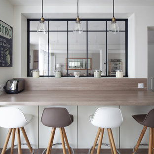Cette image montre une grand cuisine parallèle urbaine fermée avec un placard à porte plane, des portes de placard blanches, un plan de travail en stratifié, un électroménager encastrable et aucun îlot.