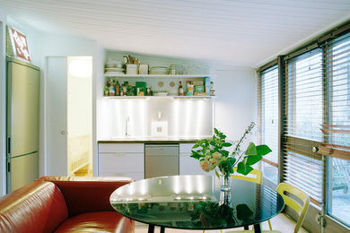 Immagine di una piccola cucina bohémian con lavello sottopiano, ante a filo, ante bianche, top in laminato, elettrodomestici in acciaio inossidabile e parquet chiaro