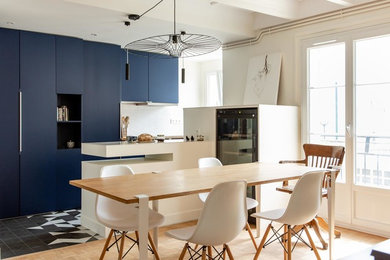 パリにあるお手頃価格の中くらいなコンテンポラリースタイルのおしゃれなキッチン (アンダーカウンターシンク、インセット扉のキャビネット、青いキャビネット、珪岩カウンター、白いキッチンパネル、テラコッタタイルのキッチンパネル、黒い調理設備、白いキッチンカウンター) の写真