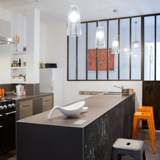 Réalisation d'une cuisine ouverte urbaine de taille moyenne avec des portes de placard en bois brun, une crédence marron, un sol en carrelage de céramique, une péninsule, un évier 2 bacs et un électroménager noir.