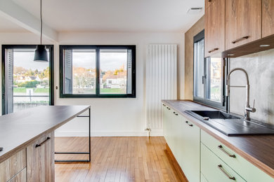 Cette photo montre une cuisine ouverte parallèle tendance avec un évier intégré, des portes de placards vertess, un plan de travail en bois, une crédence verte, parquet foncé, îlot et un sol gris.