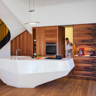 Idee per una grande cucina minimal con lavello integrato, ante marroni, pavimento in legno massello medio e isola