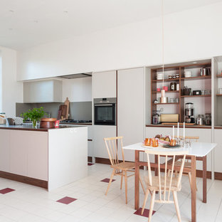Inspiration pour une cuisine américaine nordique avec un placard sans porte, une crédence grise, un électroménager en acier inoxydable, un îlot central, un sol multicolore et un plan de travail marron.