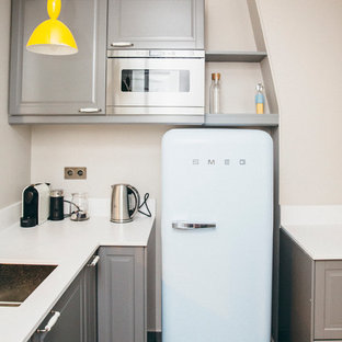 Aménagement d'une petit cuisine contemporaine en L fermée avec des portes de placard grises, un électroménager encastrable et aucun îlot.