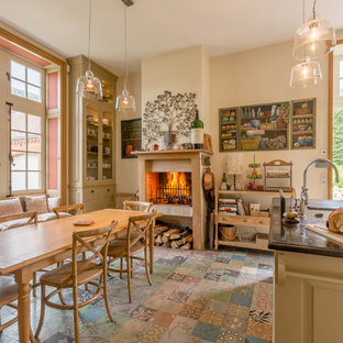 Réalisation d'une cuisine américaine champêtre avec un îlot central et un sol multicolore.