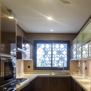 Inspiration pour une cuisine minimaliste en U fermée et de taille moyenne avec un évier 3 bacs, un placard à porte vitrée, des portes de placard marrons, un plan de travail en quartz, une crédence beige, une crédence en carreau de porcelaine, un électroménager en acier inoxydable, un sol en carrelage de porcelaine et un sol beige.