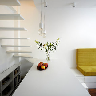 Idée de décoration pour une petit cuisine ouverte parallèle design avec un placard sans porte, des portes de placard blanches et un îlot central.