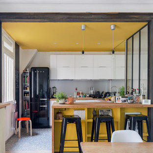 Inspiration for a small contemporary u-shaped open plan kitchen in Paris with a double-bowl sink, beaded inset cabinets, white cabinets, wood benchtops, grey splashback, metal splashback, black appliances, cement tiles, with island and multi-coloured floor.