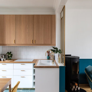 Diseño de cocina en L, moderna, de tamaño medio, abierta, sin isla, con fregadero de un seno, armarios con rebordes decorativos, puertas de armario de madera clara, encimera de madera, salpicadero blanco, salpicadero de azulejos de cerámica, electrodomésticos blancos, suelo de azulejos de cemento, suelo azul y encimeras beige