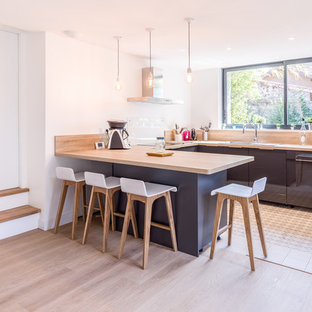 Exemple d'une cuisine tendance en U de taille moyenne avec un plan de travail en bois, un évier posé, un placard à porte plane, des portes de placard grises, une crédence en fenêtre et une péninsule.