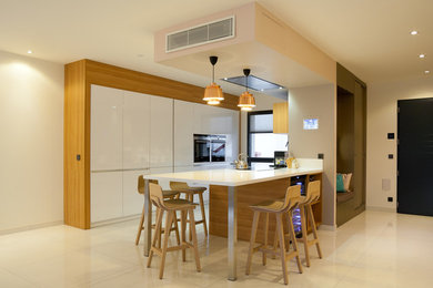 Cette image montre une cuisine ouverte design en U de taille moyenne avec des portes de placard blanches, un électroménager en acier inoxydable, un sol en carrelage de céramique et une péninsule.