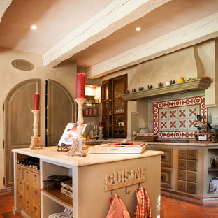 Cette image montre une cuisine parallèle rustique fermée avec des portes de placard en bois vieilli et un îlot central.