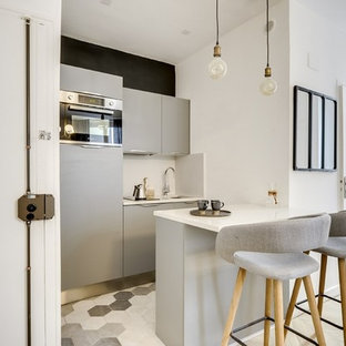 Design ideas for a small modern galley open plan kitchen in Paris with quartzite benchtops, with island, an integrated sink, flat-panel cabinets, grey cabinets, white splashback, stainless steel appliances, cement tiles, grey floor and white benchtop.